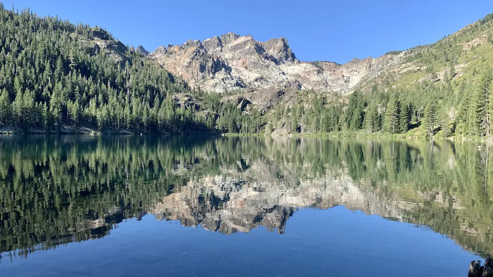 Bergsee, in dem sich im Sommer die Gipfel spiegeln