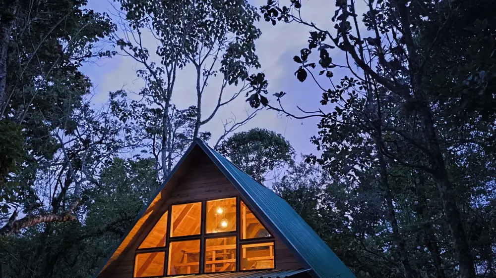 A-Frame-Hütte bei Nacht im verschneiten Wald